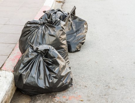 Operatives loading a commercial bin during rubbish removal